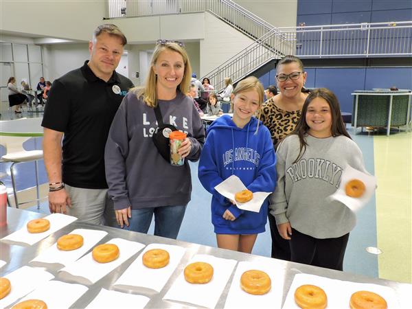 Students having pastries with their parents. 